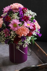 Still life Bouquet of  various flowers in a vase against dark moody background, selective focus