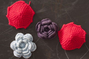 Rose blue and purple color from yarn with umbrella red color on chalkboard.