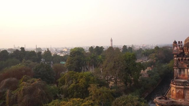 Panning shot of Lucknow cityscape starting from the Bara Imambara and moving to the homes and residences. Shot at sunset with a beautiful red sky. This is one of the most imposing buildings in Uttar