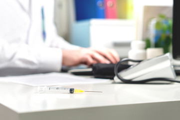 Vaccine, flu or influenza shot or blood test needle on doctor office table. Medicine, insulin or...
