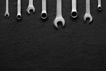 Wrenches on black textured background.