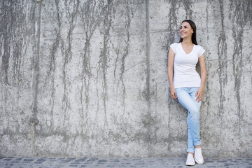 Everything will be cool. Attractive young woman near a concrete wall.