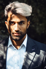 Brutal young businessman with beard gray. Stylish Afghan man in jacket costume on the nordic Karelian nature landscape background. Marble Canyon and Dramatic sky in Karelia   republic. Karelian fores