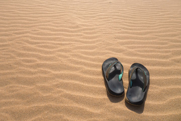 Fototapeta na wymiar Flip flops in the sand beach
