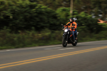 Fototapeta na wymiar Couple sur une moto qui roule à toute vitesse