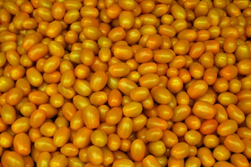 Full frame vibrant yellow miniature plum tomatos on a stall at Borough Market, London, UK