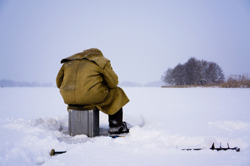 Close up Lone fisherman ice fishing on the river.