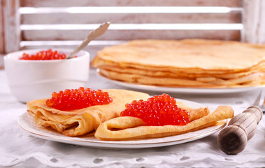 Thin pancakes with red caviar