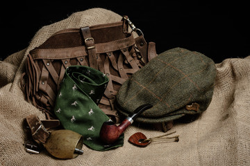 Hunting gear spread out on old cloth with a black background