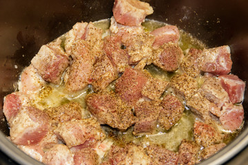 Chopped pork meat cooking in slow cooker