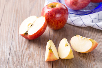Fresh red apple and slice on a wooden table.