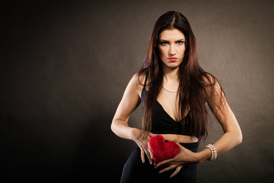Beautiful woman holds red heart on black