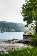 Old norwegian cottage by lake and forest