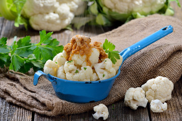 Gegarter Blumenkohl mit in Butter gebräunten Semmelbrösel im Shabby-Emailletopf dampfend serviert...