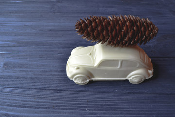 Fototapeta na wymiar Toy car with cone on the roof. Decor on the dark blue wooden background.