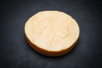 Whole round Head of parmesan or parmigiano hard cheese on concrete background