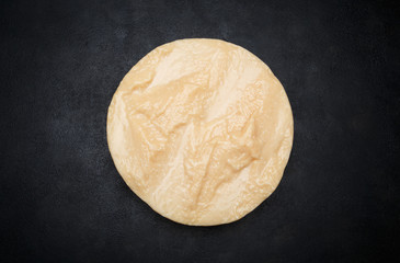 Whole round Head of parmesan or parmigiano hard cheese on concrete background
