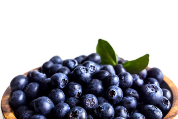 Juicy and fresh blueberries with green leaves on white bowl. Healthy eating