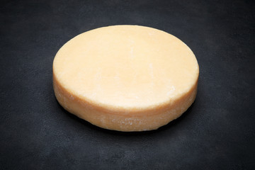 Whole round Head of parmesan or parmigiano hard cheese on concrete background