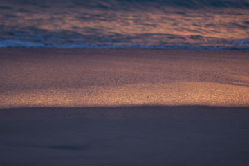 Blured wave on sand beach. Twilight.