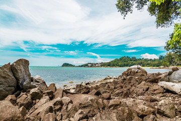 каменный пляж с видом на море и джунгли на острове Пулау Бесар в Малазии
