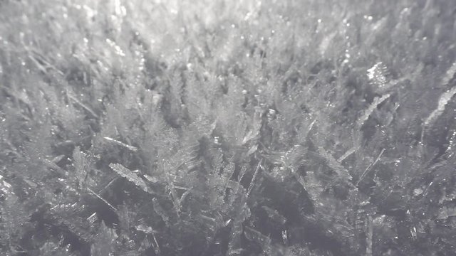 Icy frozen snowflake formations. Frozen water crystals covering snow blanket on cold