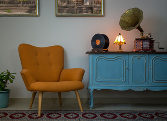 Vintage interior of retro orange armchair, vintage wooden light blue sideboard, old phonograph...
