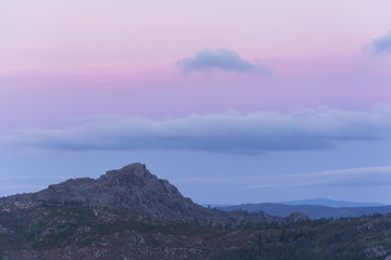 Sunrise in the mountains of Gerês. Rugged mountains and sky with orange/purple clouds 