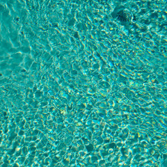 Reflected light on the surface ripples of a blue swimming pool