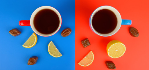 Red and blue cups with tea , lemon slices and chocolate candies on a red and blue background. Wide photo.