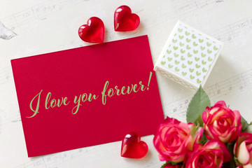 Valentines day greeting card with roses gift box hearts and lettering I love you forever.