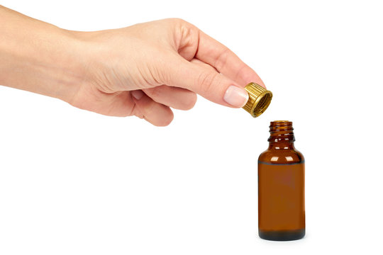 Open bottle with medical elixir, syrup for colds, antipyretic suspension in hand. Isolated on white background. Health and medicine