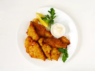 Papier Peint photo autocollant Poisson Filets de poisson frits en pâte dorée, servis sur une assiette blanche avec sauce et citron