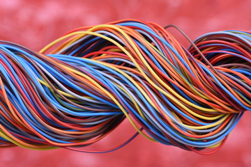 Multicolored electrical cable on red background