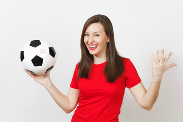 Beautiful European young cheerful happy woman, football fan or player in red uniform holding classic soccer ball isolated on white background. Sport, play football, health, healthy lifestyle concept.