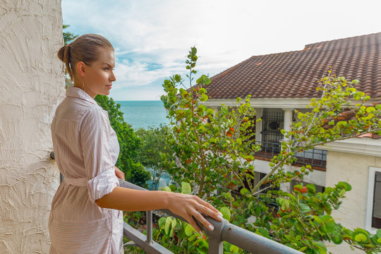молодая женщина стоит на балконе и смотрит на море на острове Пулау бесар в Малакке Малайзия 