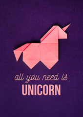 Handmade pink trendy geometrical polygonal paper origami unicorn on dark violet background. All you need is unicorn quote. Vertical poster, postcard, banner. © mykolastock