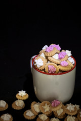 eine Tasse gefüllt mit kleinen verzierten Keksen