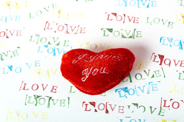 Fluffy red heart against background with the word love in different colors. Valentine's Day...