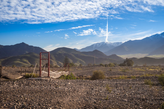 Landscape of Elqui Valley with a bridge in Vicuña, Chile. The mountains, river and clouds