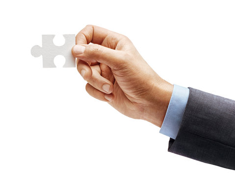 Man's hand in suit holding one puzzle element isolated on white background. Close up. High resolution product