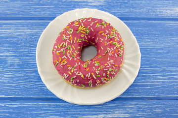 pink donut on a blue wooden background