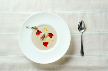 exquisite mushroom soup puree with pepper, table setting, cozy restaurant serve on a light background