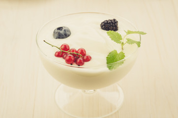 yogurt with berries in glass on a wooden background/yogurt with berries in glass on a wooden white background. selective focus