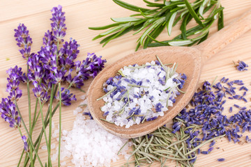 herbal salt / top view of a spoon with herbal salt of rosemary and lavender blossoms on a wooden background