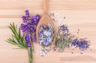  rosemary and lavender / top view of a spoon with herbal salt of rosemary and lavender blossoms on a wooden background