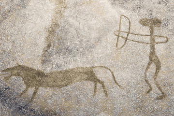 The scene of the ancient man's hunting on the wall of the cave.