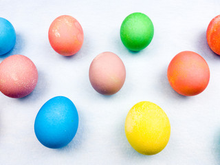 Color easter eggs on pastel blue background. Close up.