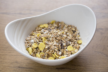 white bowl full of healthy oatmeal with fruits on wooden table