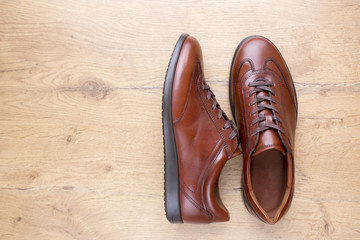 Brown men leather shoes on wooden background